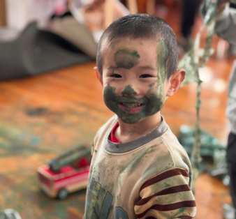 Kid Smiling while having paint on face in our avondale heights childcare